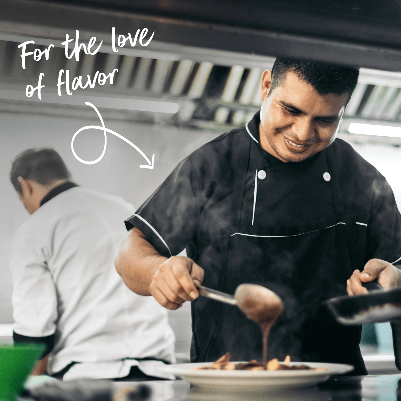 A chef pours sauce on a plate in a restaurant kitchen.